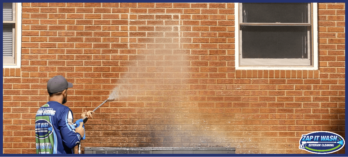 pressure-washing-technician-washing-a-brick-house-exterior